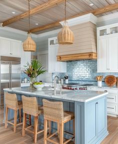 a large kitchen with an island in the middle and chairs at the counter top,