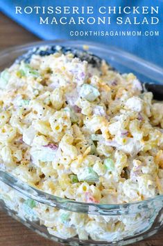 a glass bowl filled with macaroni salad on top of a wooden table