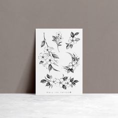 a greeting card with black and white flowers on it, sitting on a marble surface