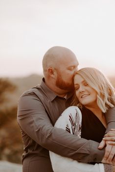 a man and woman embracing each other in the desert