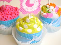 three cupcakes decorated with pink, green and blue icing