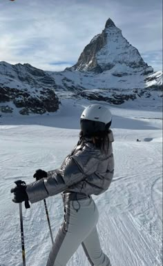 a woman on skis is standing in the snow with her back to the camera