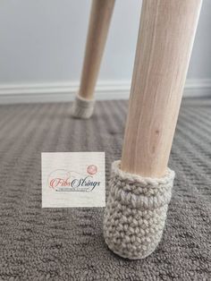 a close up of a person's legs wearing slippers and holding a business card