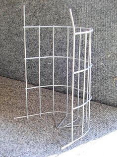 a white metal shelf sitting on top of a carpeted floor next to a wall