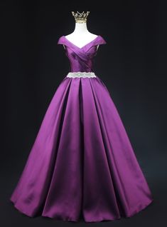 Functionally elegant, this purple prom dress is a perfect blend of classic beauty and modern style. The gown features an off-the-shoulder neckline with intricate pleating that adds a touch of sophistication. The fitted bodice is highlighted by a sparkling belt that accentuates your waist, creating a flattering silhouette. The full skirt, crafted from luxurious satin fabric, flows gracefully to the floor, providing a dramatic and regal look. The rich purple color ensures you stand out in any crowd, making this dress perfect for making a memorable entrance. Step into this gown and let its exquisite design and vibrant color elevate your prom night to an unforgettable experience. Purple Royal Dress, Royal Purple Dress, Simple Satin, Corset Looks, Bodice Applique, Neck Corset, Purple Prom, Purple Prom Dress, Royal Dresses