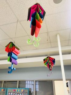 several colorful kites are hanging from the ceiling in an office building or school room