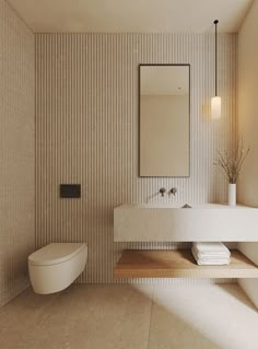 a white toilet sitting next to a sink in a bathroom under a mirror and lights