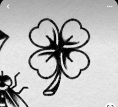 a black and white drawing of a bug next to a four leaf clover with a ladybug on it