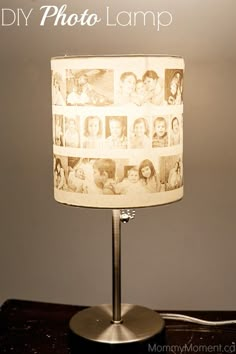 a lamp with pictures on it sitting on a table next to a phone and remote control