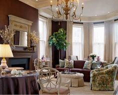 a living room filled with lots of furniture and a chandelier above a fire place