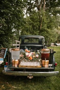 an old truck with flowers and drinks in the back