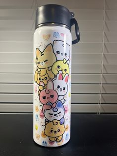 a stainless steel water bottle with cats and kittens all over it, sitting on a table