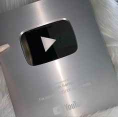 an electronic device with a play button on the front and side of it's cover