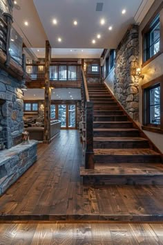 the interior of a house with wood floors and stone staircase leading up to an open floor plan