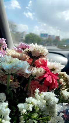 a bunch of flowers sitting in the front seat of a car