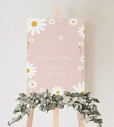 a pink sign with daisies on it that says, welcome to charlotte first birthday