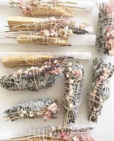 dried flowers and sticks are arranged on a white surface with twine wrapped around them