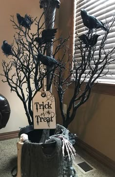 there is a fake tree that has been decorated with black branches and birds on it