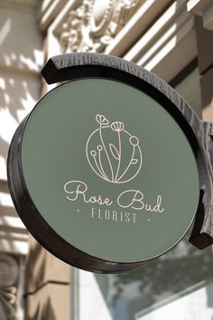 the sign for rose bud florist is hanging from the side of a building