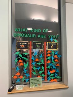 a window display with dinosaurs in the front and behind it that says, what kind of dinosaur are you?