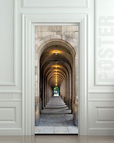 an archway leading into a building with light at the end and stone flooring on both sides