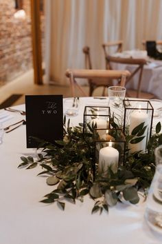 a table with candles and greenery is set up for a wedding reception at two twenty