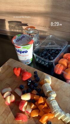 fruit and yogurt are on a cutting board next to an ice cream container