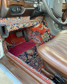 the interior of a car with leather seats and carpeted flooring, including a steering wheel