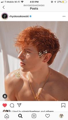 a woman with red hair wearing gold necklaces and flowers in her hair is looking at the camera