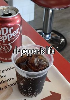 a can of dr pepper is sitting next to a drink on a tray with the caption dr pepper is life