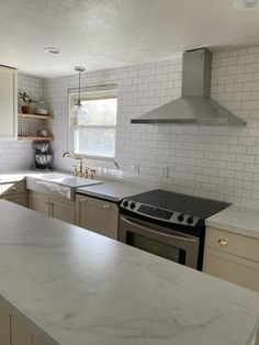 a kitchen with an oven, stove and sink in it's center island area