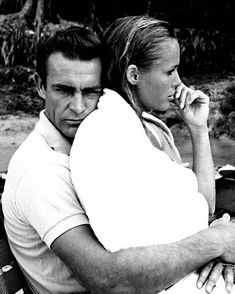 a man and woman sitting next to each other on top of a park bench together