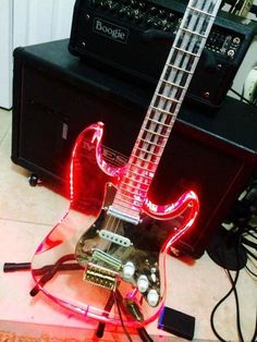 an electric guitar that is sitting on the floor with some wires in front of it