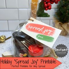 the holiday spread joy printable is displayed in front of a potted christmas tree