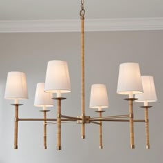 a chandelier with six lamps hanging from it's sides in a room