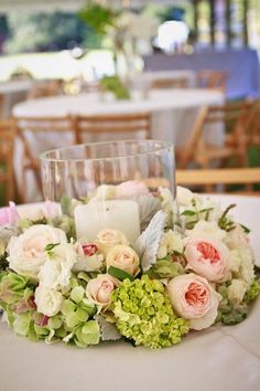 a centerpiece with candles and flowers on a table