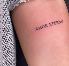 a woman's arm with the word amr eterno tattooed on it