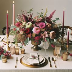 a table set with flowers and candles for a formal dinner or wedding reception in pinks, golds and greens