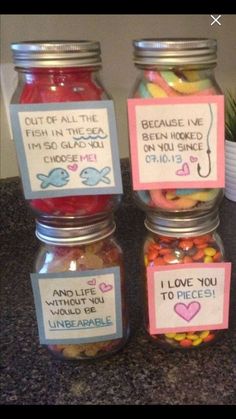 four jars filled with different types of candy