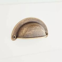 an antique brass door handle on a white cabinet