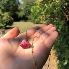 a person holding a rose in their hand with a chain attached to the end of it