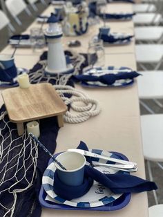 the table is set with blue and white plates, napkins, and utensils