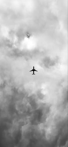 an airplane is flying high in the cloudy sky