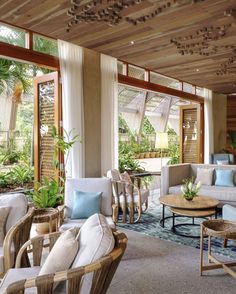 a living room filled with lots of furniture and plants on top of it's walls