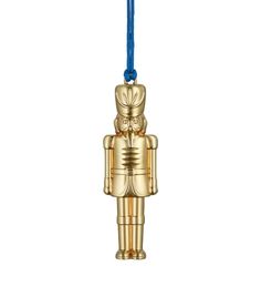 an ornament in the shape of a gold toy with a blue cord hanging from it