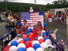 some people are sitting in a float with balloons