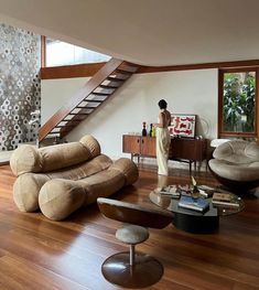 a living room filled with furniture and a stair case next to a wooden flooring