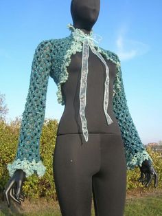 a mannequin wearing a crocheted blue and white scarf