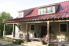 a house with red metal roof and white trim