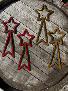 three metal stars sitting on top of a wooden table